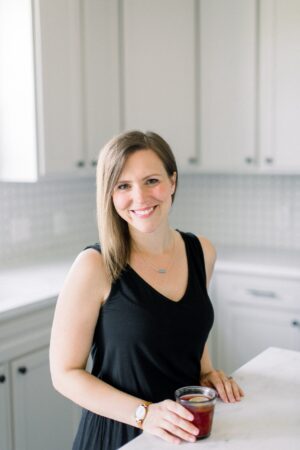 CEO, Erin Jensen, standing next to a kitchen island with an iced tea.