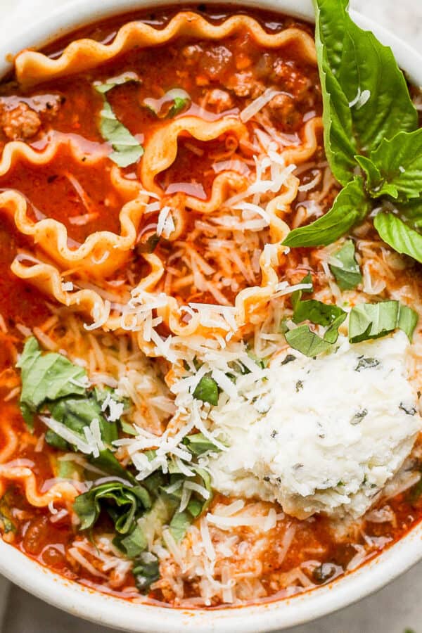 Bowl of homemade lasagna soup with ricotta, fresh basil and parmesan cheese.