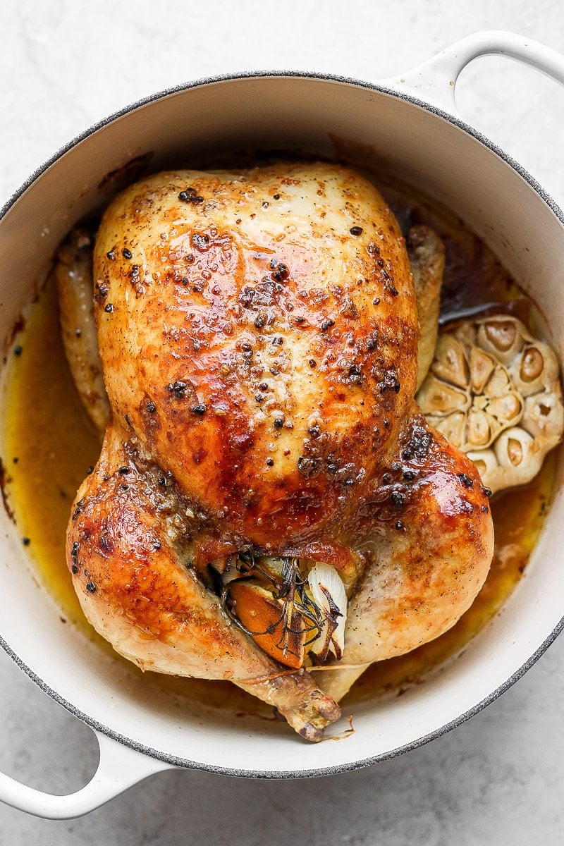 The BEST Whole Roasted Chicken - a cozy, tried and true whole roasted chicken recipe that will not disappoint! Step-by-step photos! #wholeroastedchicken #howtoroastawholechicken #wholechickenrecipeeasy #wholechickenrecipehealthy Whole roasted chicken in a dutch oven.