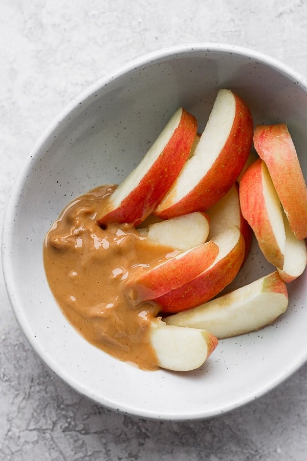 Whole30 Snacks - a list of over 17 Whole30 compliant snacks! Keep your snacking game interesting and satisfying! So many good ideas! #whole30snacks #whole30recipes #whole30resources #whole30 Bowl of apples with almond butter.