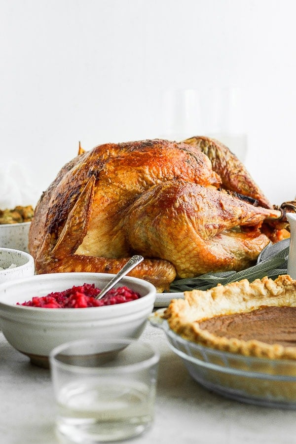 Grilled Turkey - a simple, step-by-step tutorial that will guide you through the process of cooking a (delicious) Grilled Turkey! #grilledturkey #thanksgivingrecipes #howtocookaturkey #whole30recipes #paleorecipes A whole grilled turkey on a platter.