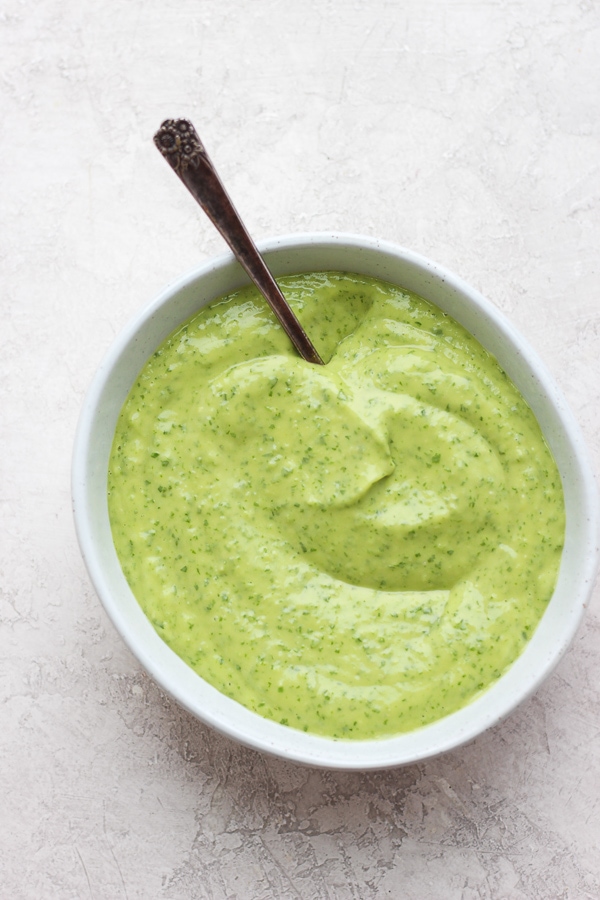 Whole30 Sauces -the staple Whole30 sauces and condiments that are so helpful to have on hand! #whole30sauces #whole30condiments #whole30recipes #paleorecipes A bowl of creamy chimichurri sauce with a spoon sticking out the side.